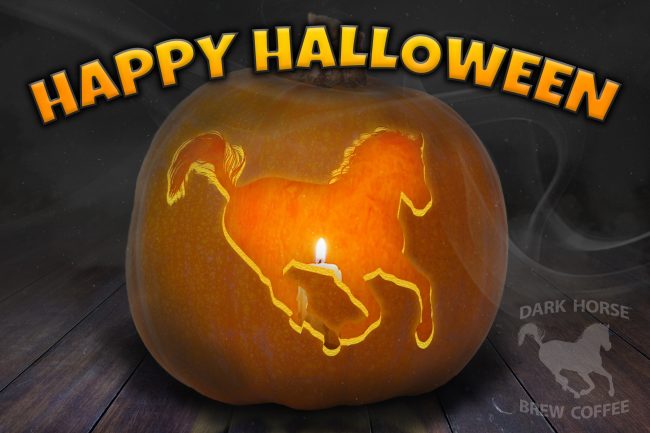 A Happy Halloween banner featuring a jack-o-lantern pumpkin with the dark horse brew logo carved out of it, illuminated by a candle.