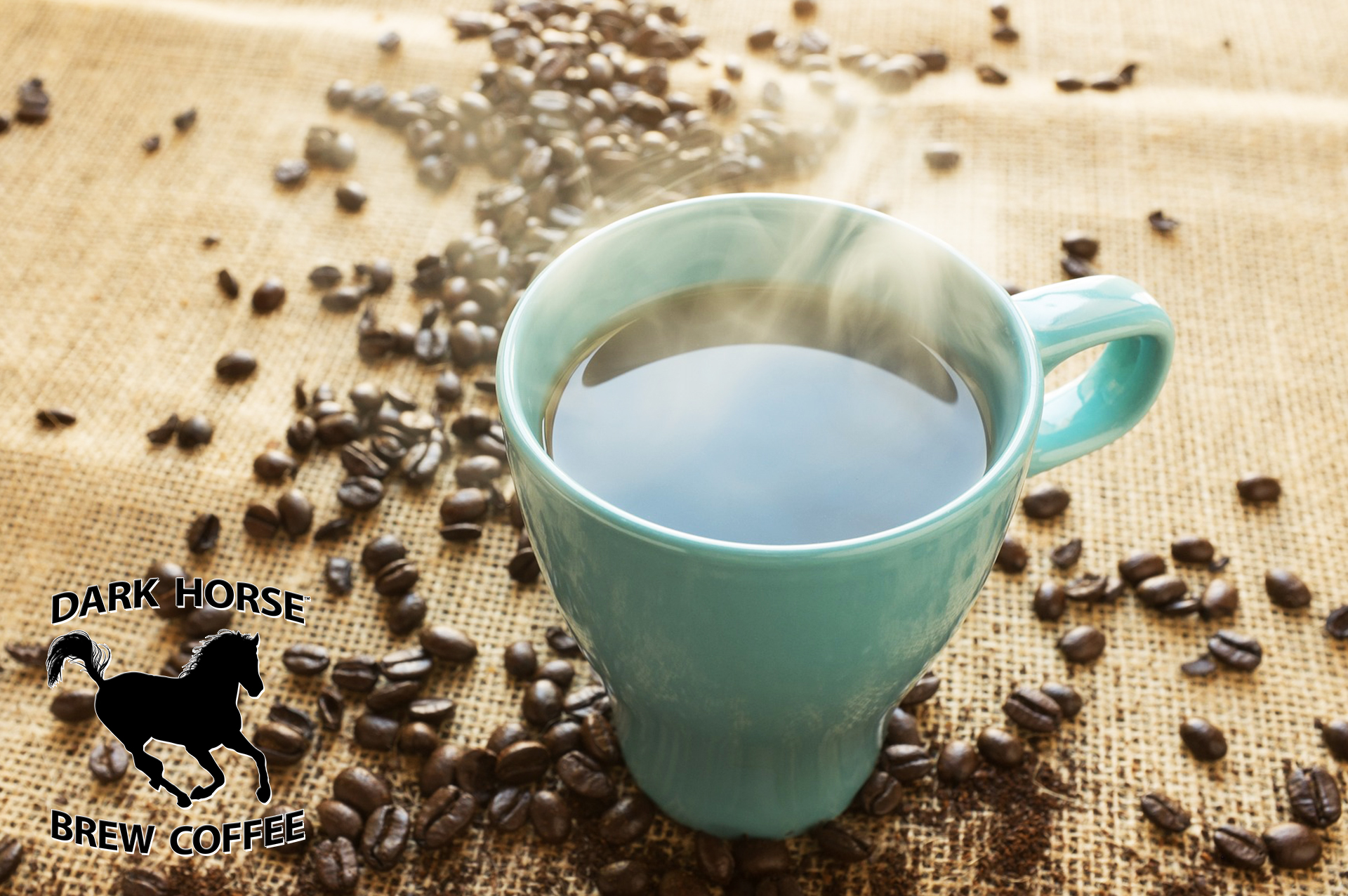 Banner of Green Mug with steaming coffee sitting on burlap fabric surrounded by scattered coffee beans.