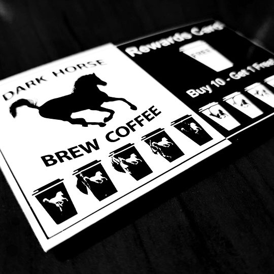 Dark Horse Brew Coffee Stamp Card laying on dark counter.